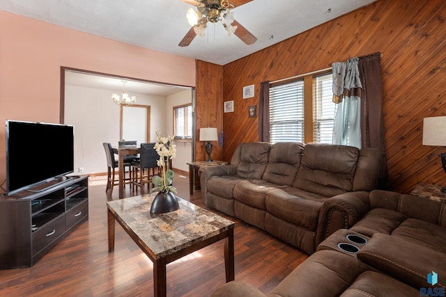 living area featuring dark wood-style floors, wooden walls, and a wealth of natural light