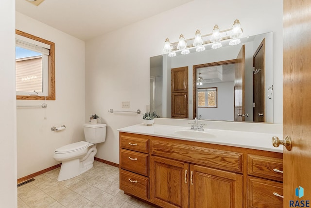 bathroom with baseboards, visible vents, vanity, and toilet