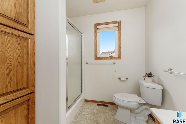 full bath featuring a stall shower, visible vents, baseboards, toilet, and tile patterned floors