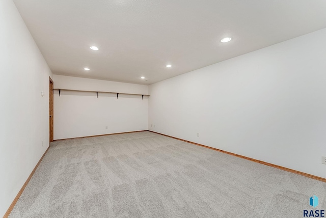 spare room with recessed lighting, light carpet, and baseboards