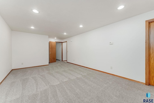 spare room with light carpet, baseboards, and recessed lighting