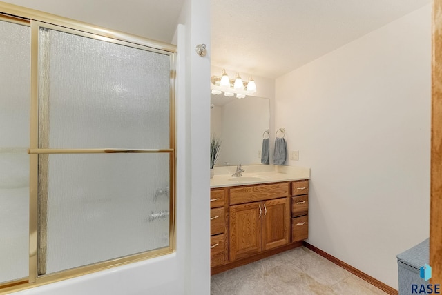 full bathroom featuring bath / shower combo with glass door, vanity, and baseboards