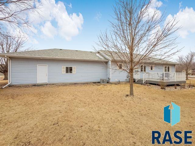 rear view of property with a deck and a yard