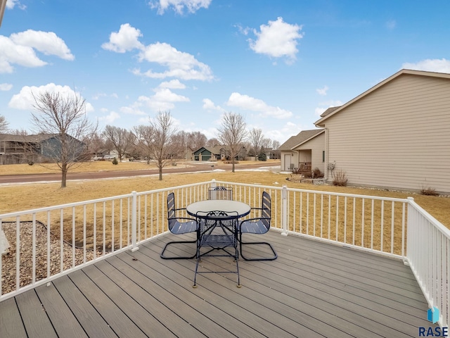 wooden deck featuring a residential view, outdoor dining area, and a lawn