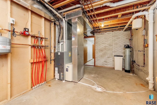 unfinished basement featuring brick wall and heating unit