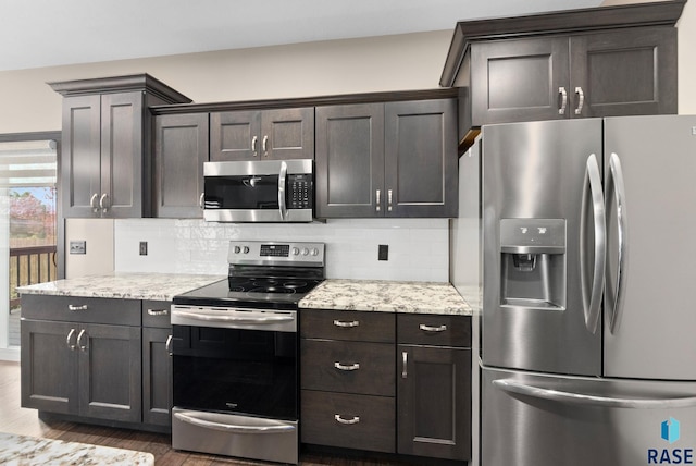 kitchen with stainless steel appliances, dark brown cabinets, light stone counters, and decorative backsplash