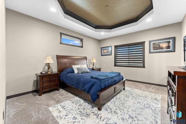 bedroom with ornamental molding, a tray ceiling, light carpet, and baseboards