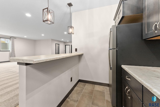 kitchen featuring recessed lighting, light countertops, hanging light fixtures, a peninsula, and baseboards