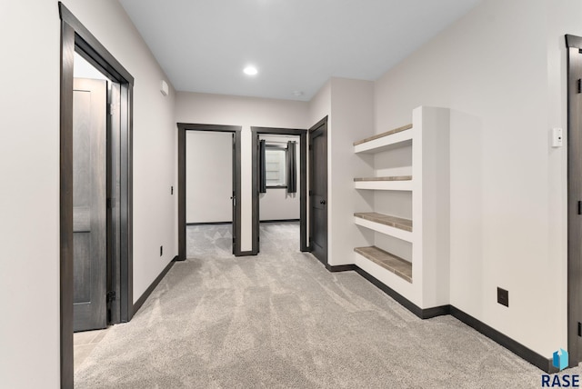 hallway featuring recessed lighting, light carpet, and baseboards