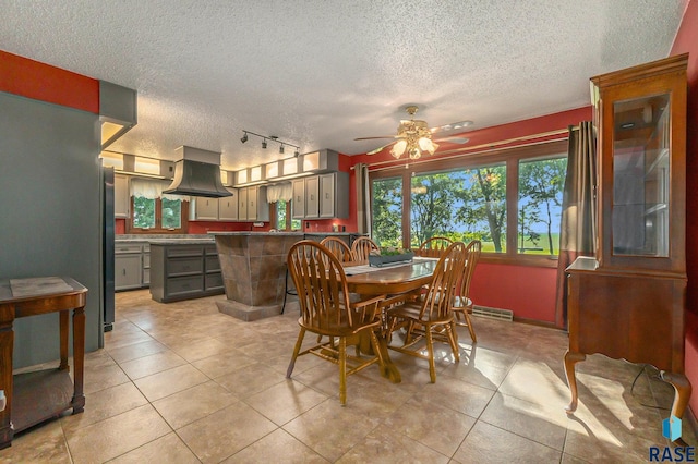 dining room featuring light tile patterned floors, ceiling fan, and a textured ceiling