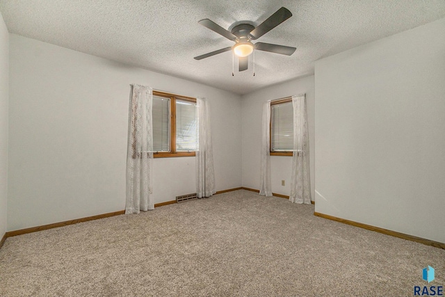 unfurnished room featuring carpet flooring, a textured ceiling, and baseboards