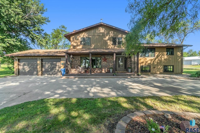 view of front of property featuring an attached garage, a porch, concrete driveway, and brick siding