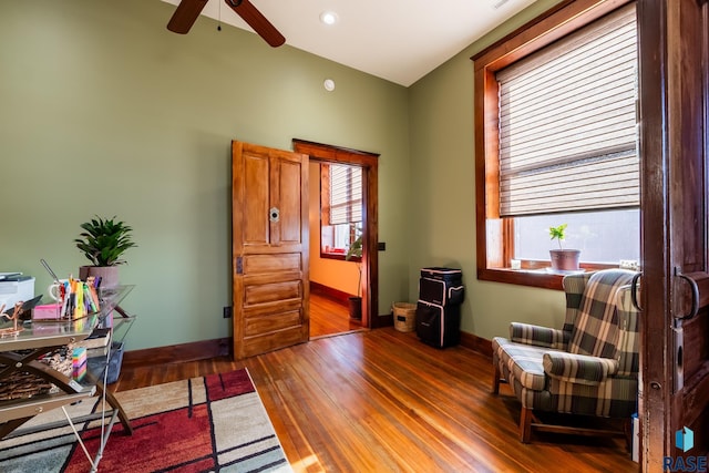 living area with wood finished floors, a wealth of natural light, and baseboards