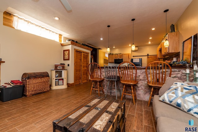 living area featuring wood tiled floor, recessed lighting, and a barn door
