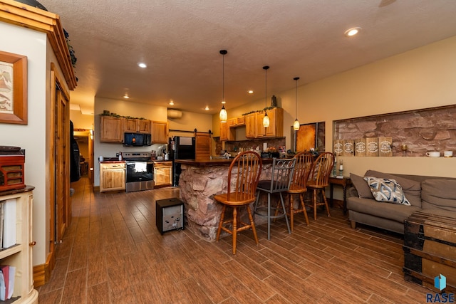 kitchen with a peninsula, open floor plan, black appliances, dark countertops, and a kitchen bar