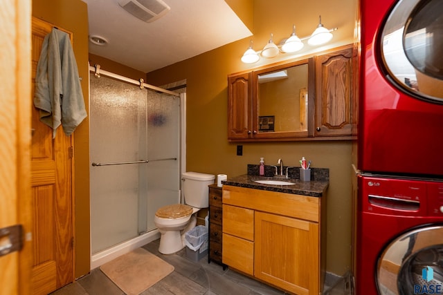 bathroom featuring a stall shower, visible vents, stacked washer / dryer, and vanity