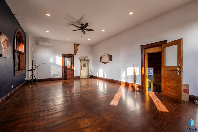 spare room featuring an AC wall unit, recessed lighting, dark wood finished floors, and baseboards
