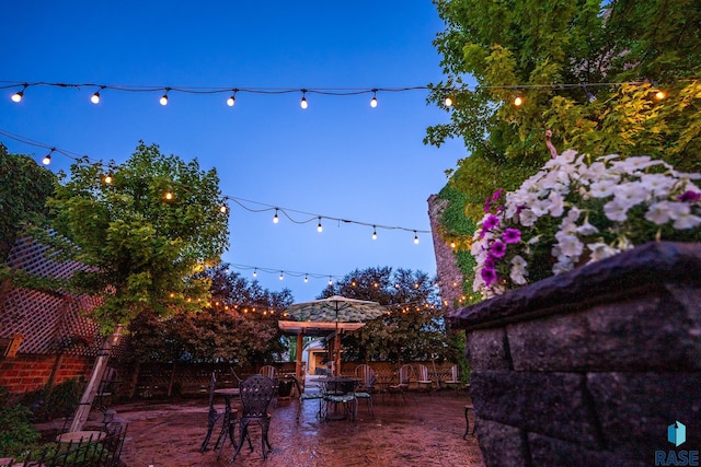 yard at dusk featuring a patio and fence
