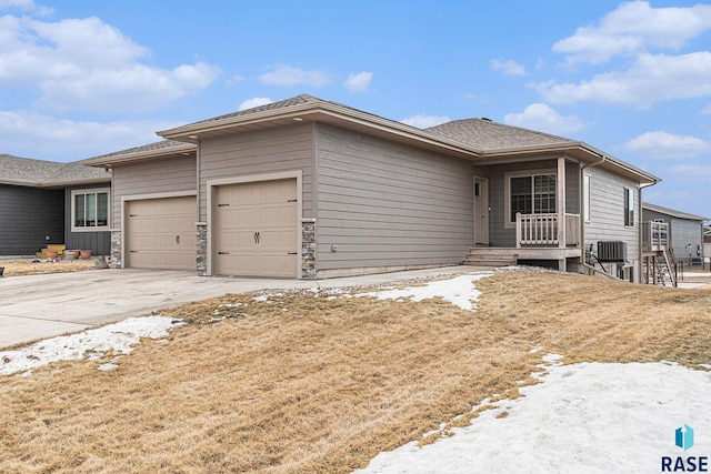 view of front of property with central AC, concrete driveway, and an attached garage