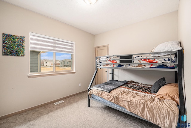 carpeted bedroom with visible vents and baseboards