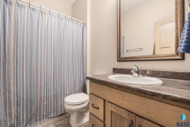 full bathroom with a shower with curtain, vanity, toilet, and wood finished floors