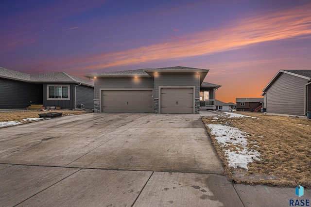 view of front of property featuring stone siding, driveway, and an attached garage