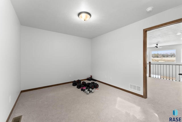 interior space featuring light colored carpet, visible vents, and baseboards