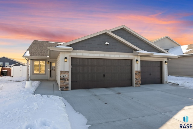 view of front facade with a garage, stone siding, and concrete driveway