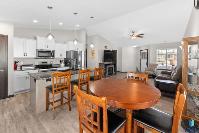 dining room with light wood-type flooring, vaulted ceiling, a ceiling fan, and recessed lighting