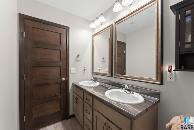 full bathroom featuring double vanity, a sink, and wood finished floors