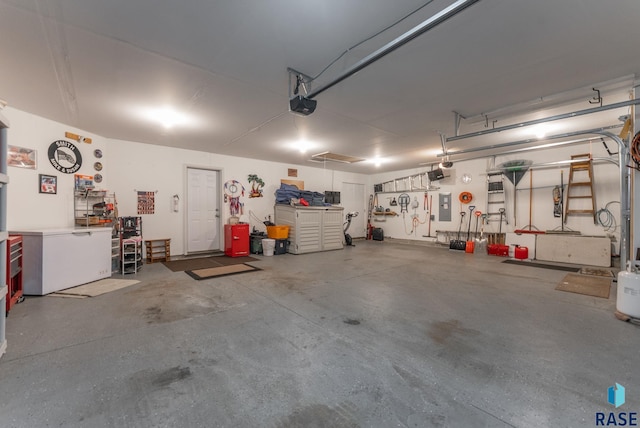 garage featuring a workshop area, electric panel, and a garage door opener