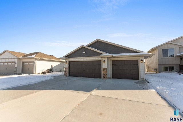 view of front of house with a garage, stone siding, and driveway