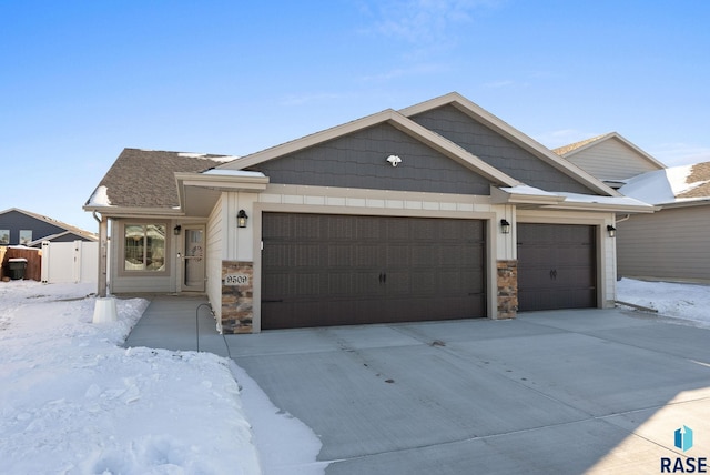 view of front of house featuring stone siding, driveway, and an attached garage