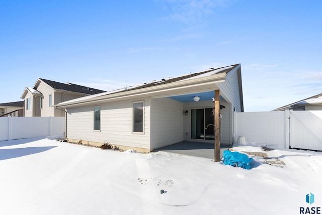 snow covered property with fence