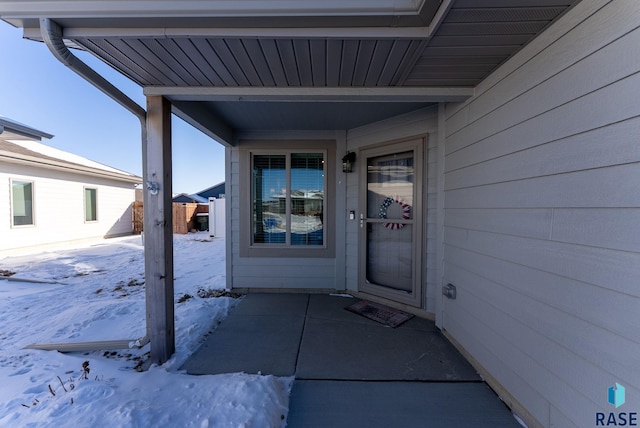 snow covered property entrance with fence