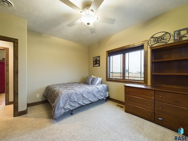 bedroom with baseboards, visible vents, a textured ceiling, and light colored carpet