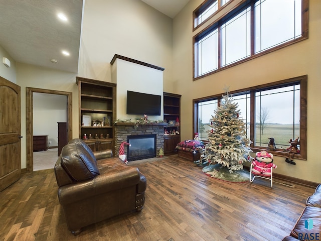 living room with a healthy amount of sunlight, a fireplace, baseboards, and dark wood-style flooring