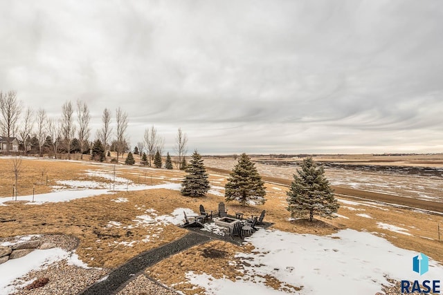 yard covered in snow featuring a rural view