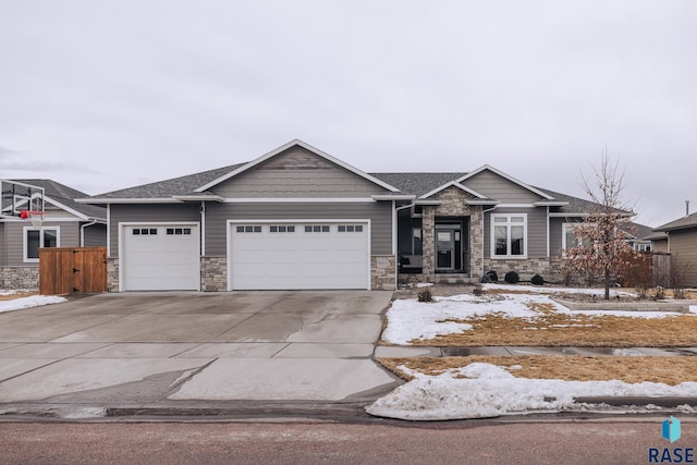 craftsman inspired home featuring an attached garage, stone siding, and concrete driveway