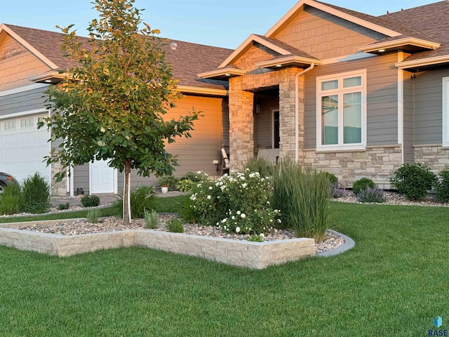 craftsman inspired home with an attached garage, stone siding, roof with shingles, and a front yard