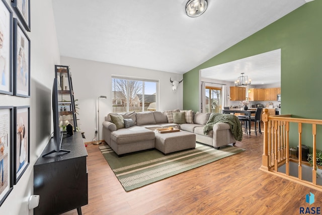 living room with plenty of natural light, an inviting chandelier, and wood finished floors