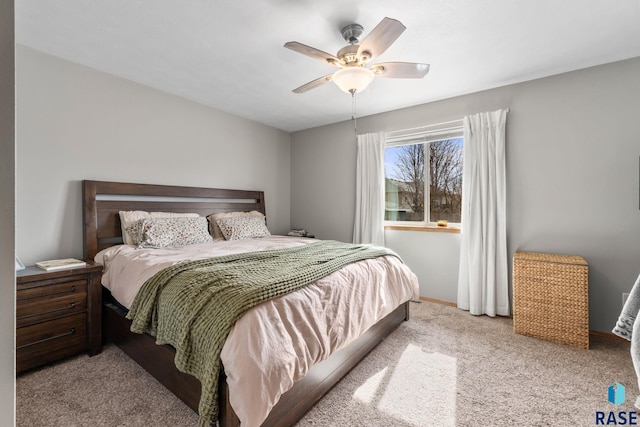 bedroom with light colored carpet, ceiling fan, and baseboards