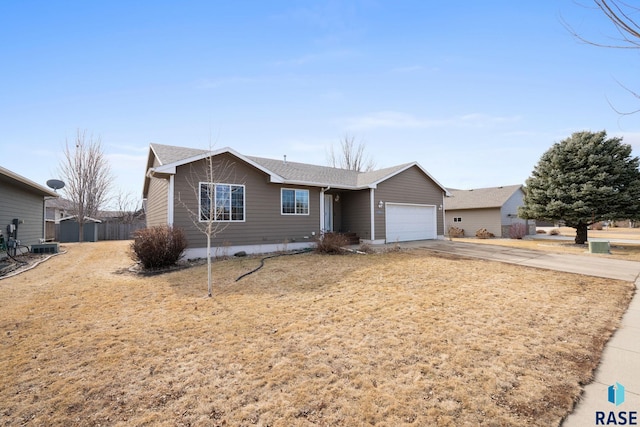 ranch-style home featuring driveway, an attached garage, and fence