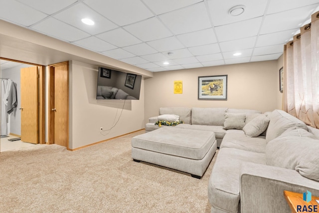 living room featuring baseboards, a drop ceiling, recessed lighting, and light colored carpet