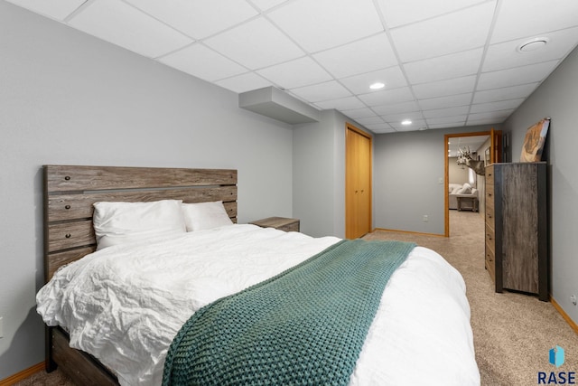 bedroom with a paneled ceiling, a closet, light colored carpet, recessed lighting, and baseboards