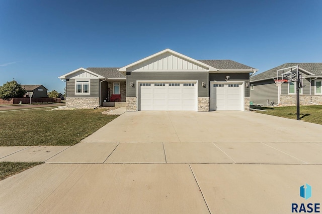 view of front of property featuring driveway, stone siding, an attached garage, a front lawn, and board and batten siding