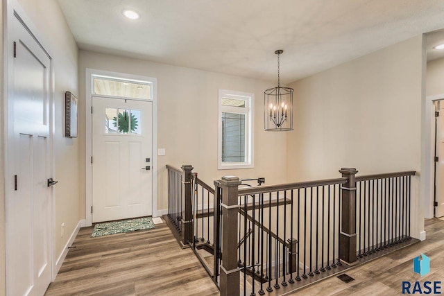 foyer with a chandelier, recessed lighting, baseboards, and wood finished floors