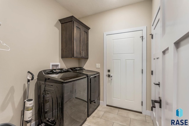 washroom featuring cabinet space, independent washer and dryer, baseboards, and light tile patterned floors