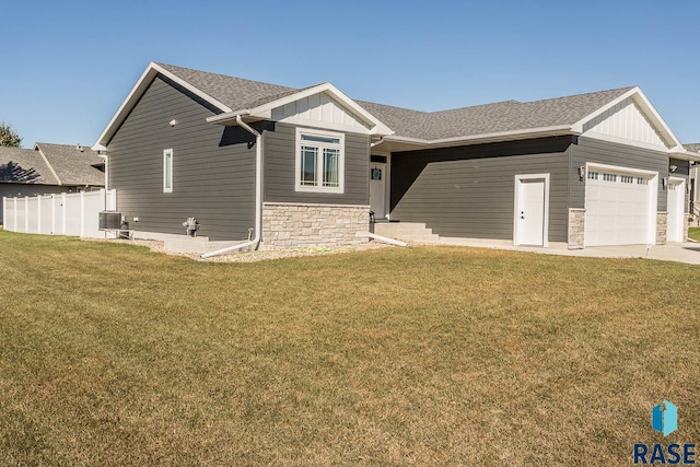 view of front facade with a garage, a shingled roof, stone siding, a front lawn, and board and batten siding