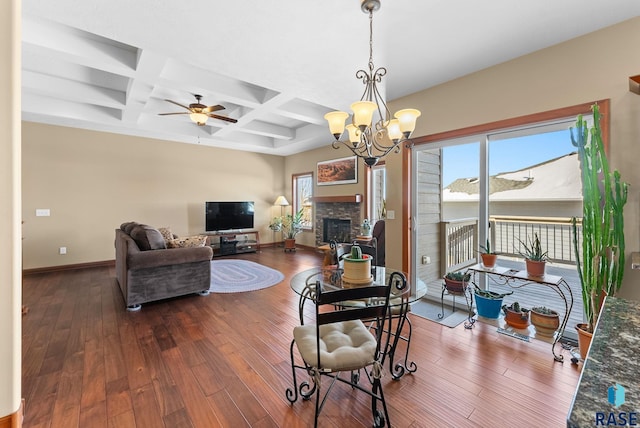 dining space featuring a stone fireplace, baseboards, and wood finished floors